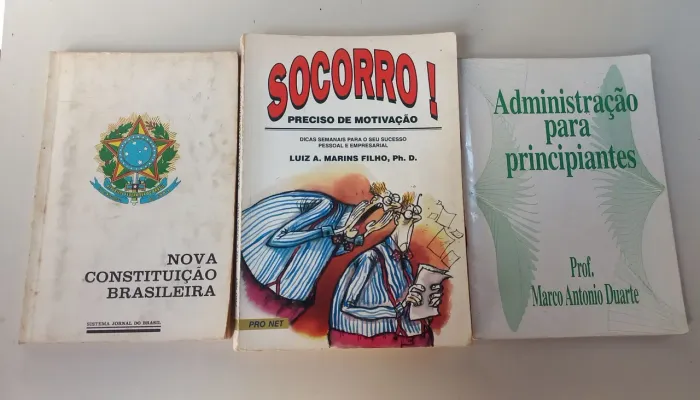 Coleção de livros variados, incluindo Constituição Brasileira, administração .