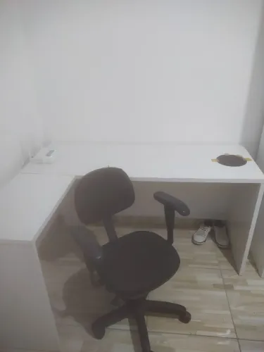 Escrivaninha branca em L e cadeira giratória preta