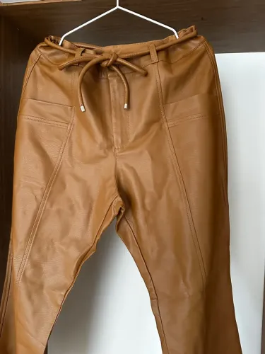 Calça de couro sintético flare caramelo com cinto e bolsos frontais