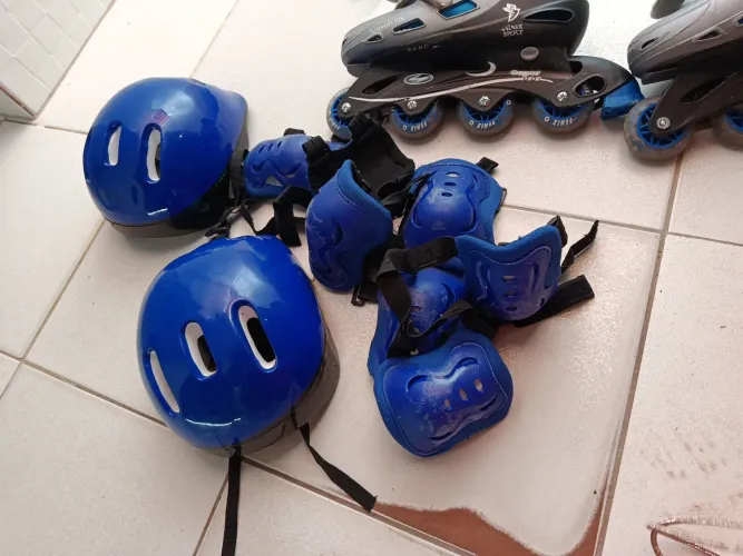 Patins, capacete, joelheira e protetor de braços.