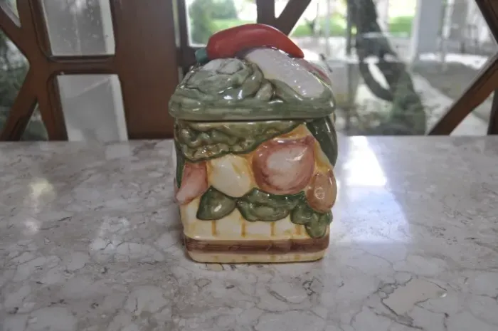 pote decorativo de cerâmica com tampa, adornado com desenhos de diversos alimentos.