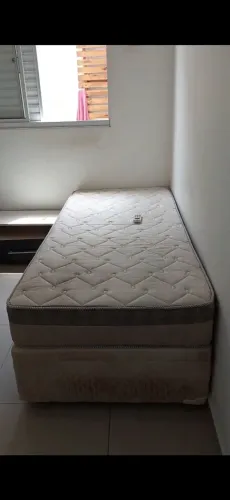 Duas camas de solteiro, uma delas é cama baú 