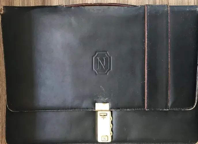 Pasta preta em couro legítimo da marca Natan com logo prensado no couro.