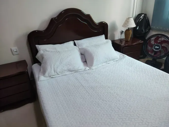 Vendo cama de madeira maciça com dois criados e um colchão.