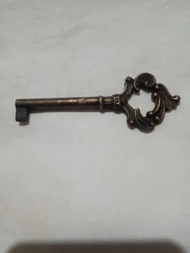 Chave antiga medindo 8,5 cm×3,5 cm com detalhes clássicos e ornamentados