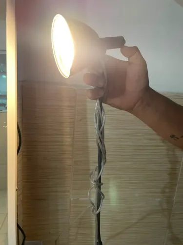 Luminária preta com luz amarelada