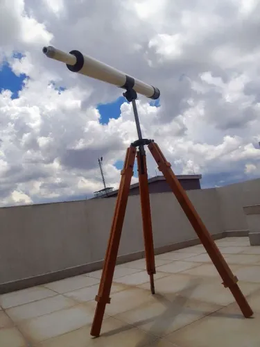 Telescópio antigo, tripé em madeira, parte ótica com conceitos de astrofísica