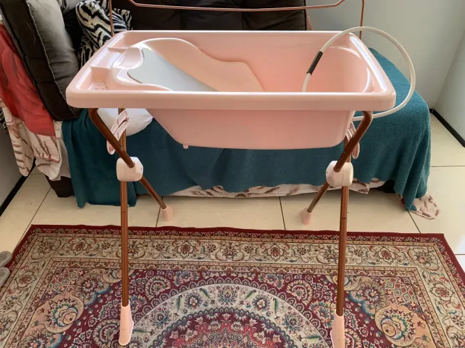 Banheira Burigotto Millenia rosa com suporte estrutural de metal e assento redutor
