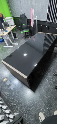 Mesa de Escritório com tampo de vidro escuro.