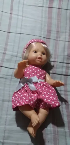 Boneca de bebê com vestido rosa de bolinhas