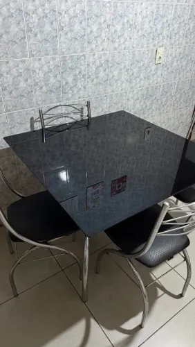 Mesa de cozinha com cadeiras com tampo de vidro preto e pés de metal