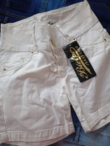 Shorts jeans na cor azul, preto e branco com tira bordada na barra. Camiseta listrada.
