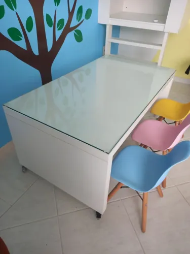 Mesa infantil para lesionar com tampo de vidro e três cadeiras. 