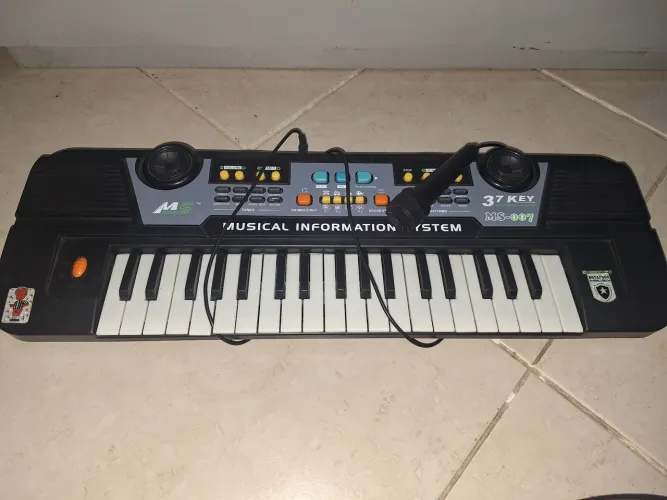 Teclado musical infantil Ms Keyboard MS-007 de 37 teclas, acompanhado de um microfone.