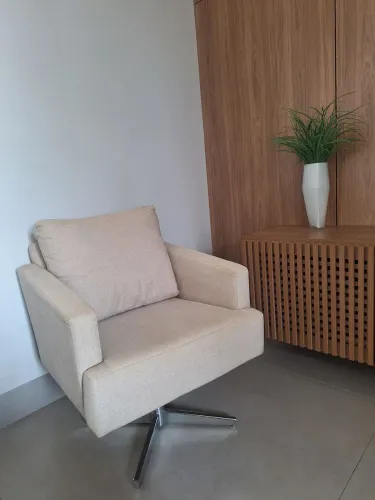 Poltrona giratória cor bege com pé cromado