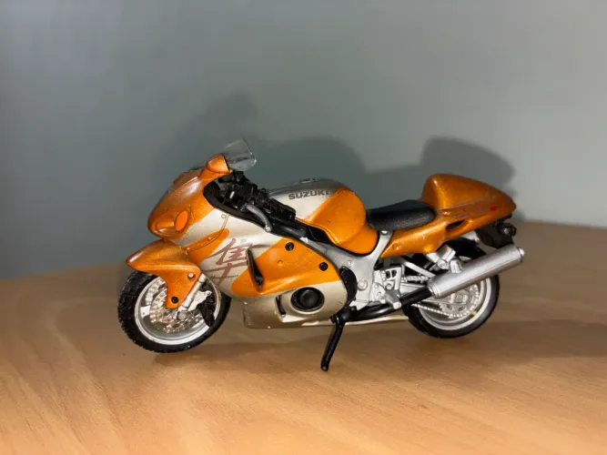 Miniatura Suzuki GSX1300R Hayabusa da Maisto, escala 1:12, com pintura dourada/laranja.