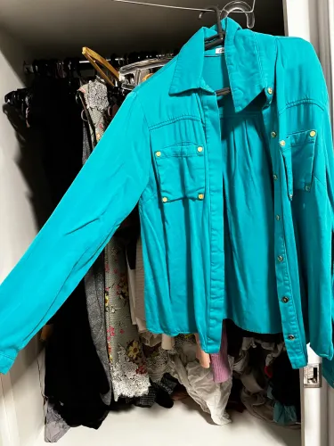 Camisa social azul clara de botões, bolsos e gola alta