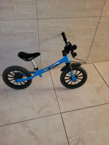 Bicicleta sem pedal azul e preta.