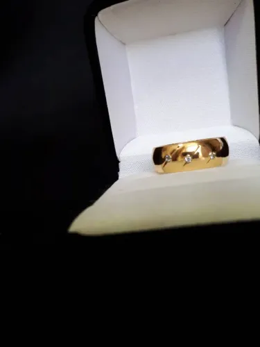 Anel tipo aliança com zirconias delicadas.