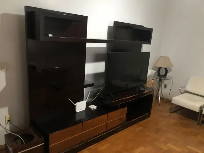 Estante moderna comprada nos móveis conquista, mesinha de canto com abajur e cachepô.