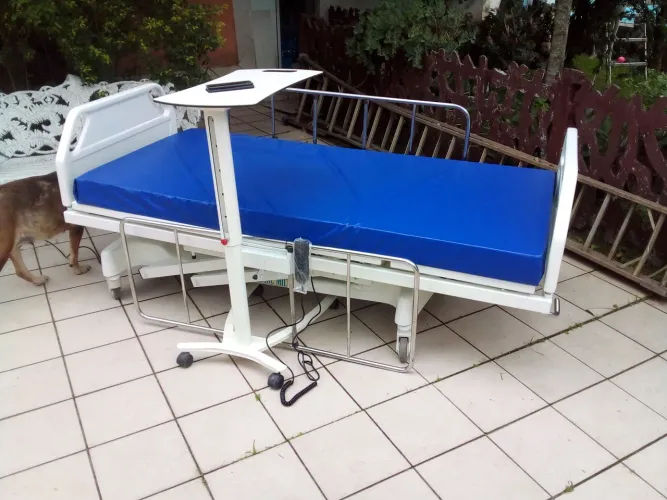 Cama hospitalar articulada com altura regulável no controle.