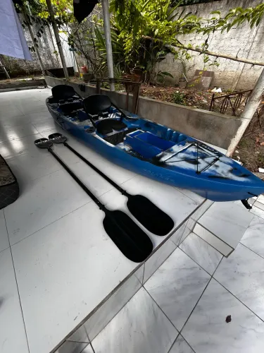 A imagem destaca um caiaque duplo azul e preto modelo New Foca da Caiaker