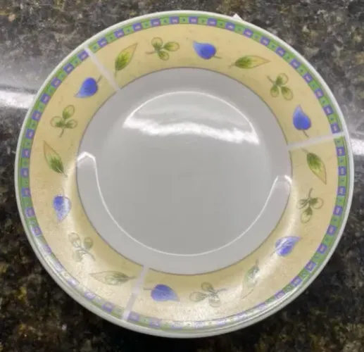 Pires de porcelana com borda amarela com cena de folhas.
