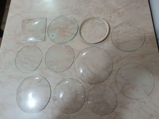 Vendo vidros antigos para relógios despertador.
