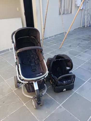 Carrinho de bebê com bebê conforto e base