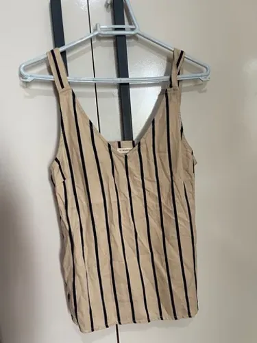 Blusa listrada com detalhe de botões atrás.