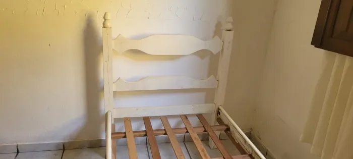 Uma cama de solteiro de madeira mais o colchão