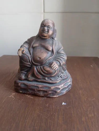 Buda sentado com avaria em uma das mãos 