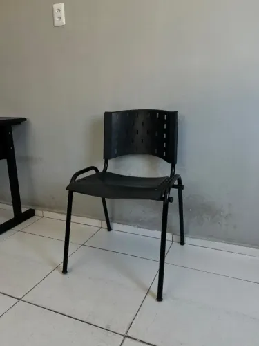 Cadeira fixa preta com encosto perfurado