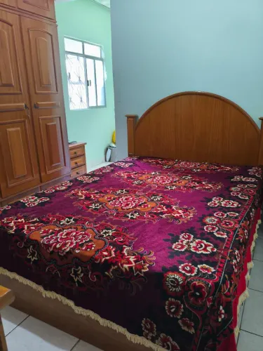 Cama casal com gavetas embutidas em ambos lados da cama, sendo três de cada lado.