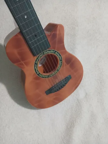 Vendo violão usado de brinquedo. Com 6 cordas de aço. Material resistente.60cm.