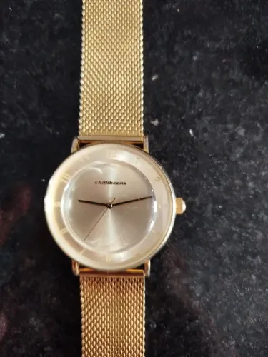 Relógio dourado marca chilli Beans apresentar uma elegante pulseira de malha