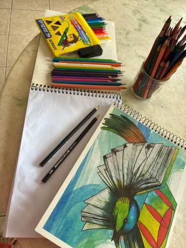 Lápis, giz de cera e caderno desenho