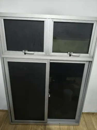 Janela de vidro e alumínio com blackout, medindo 1,00 m x 1,40 m.