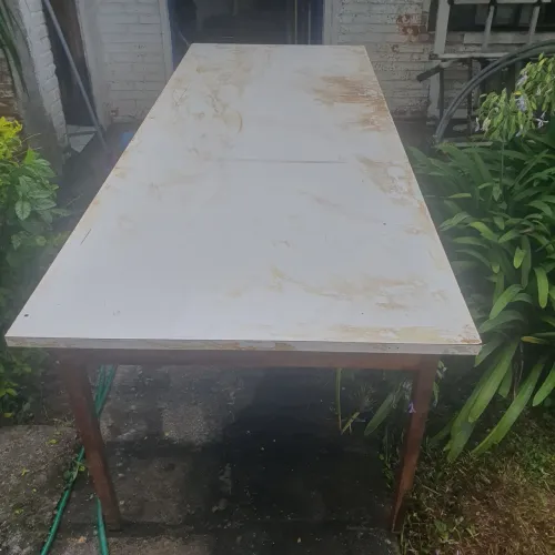 Mesa de madeira reforçada retangular de fórmica branca.