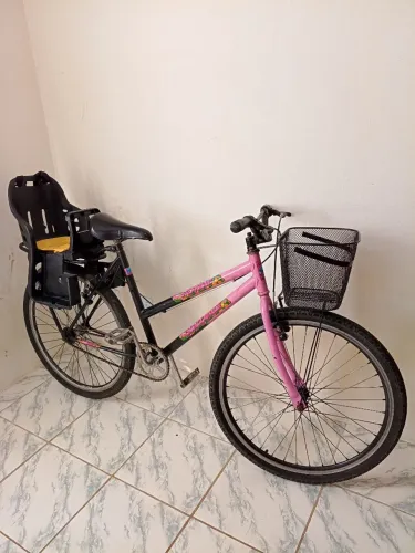 Bicicleta rosa com cadeirinha infantil