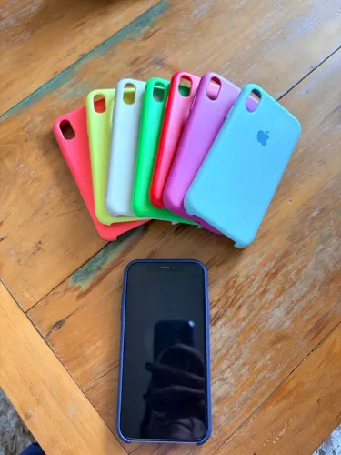Celular iPhone XR com capinhas e Apple watch