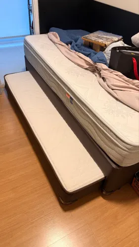 Cama solteiro com colchão auxiliar.