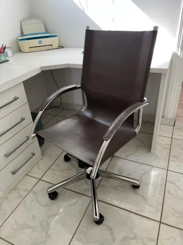 Cadeira de couro para escritório com rodízios.
