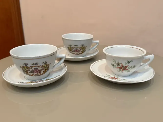 Conjunto de xícaras e pires de porcelana antigos com detalhes florais e dourados