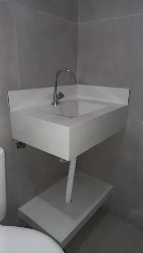 Pia esculpida em porcelanato e gabinete.