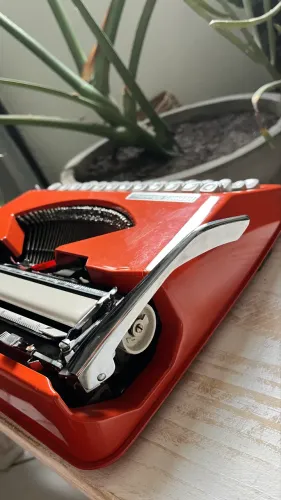 Máquina de escrever Hermes Baby vermelha com fonte cursiva