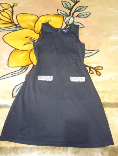 vestido preto sem mangas da marca Gap com bolsos decorados com lantejoulas. 