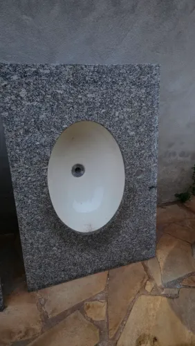 Pia de banheiro em granito com cuba oval embutida.