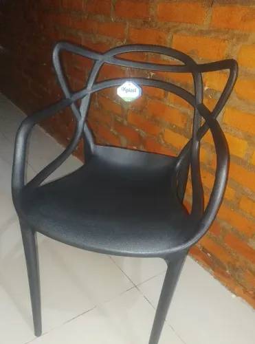 Cadeira de plástico suporta até 140 quilos, com defeito no braço.