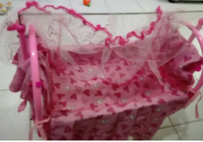 Berço de boneca rosa com mosquiteiro